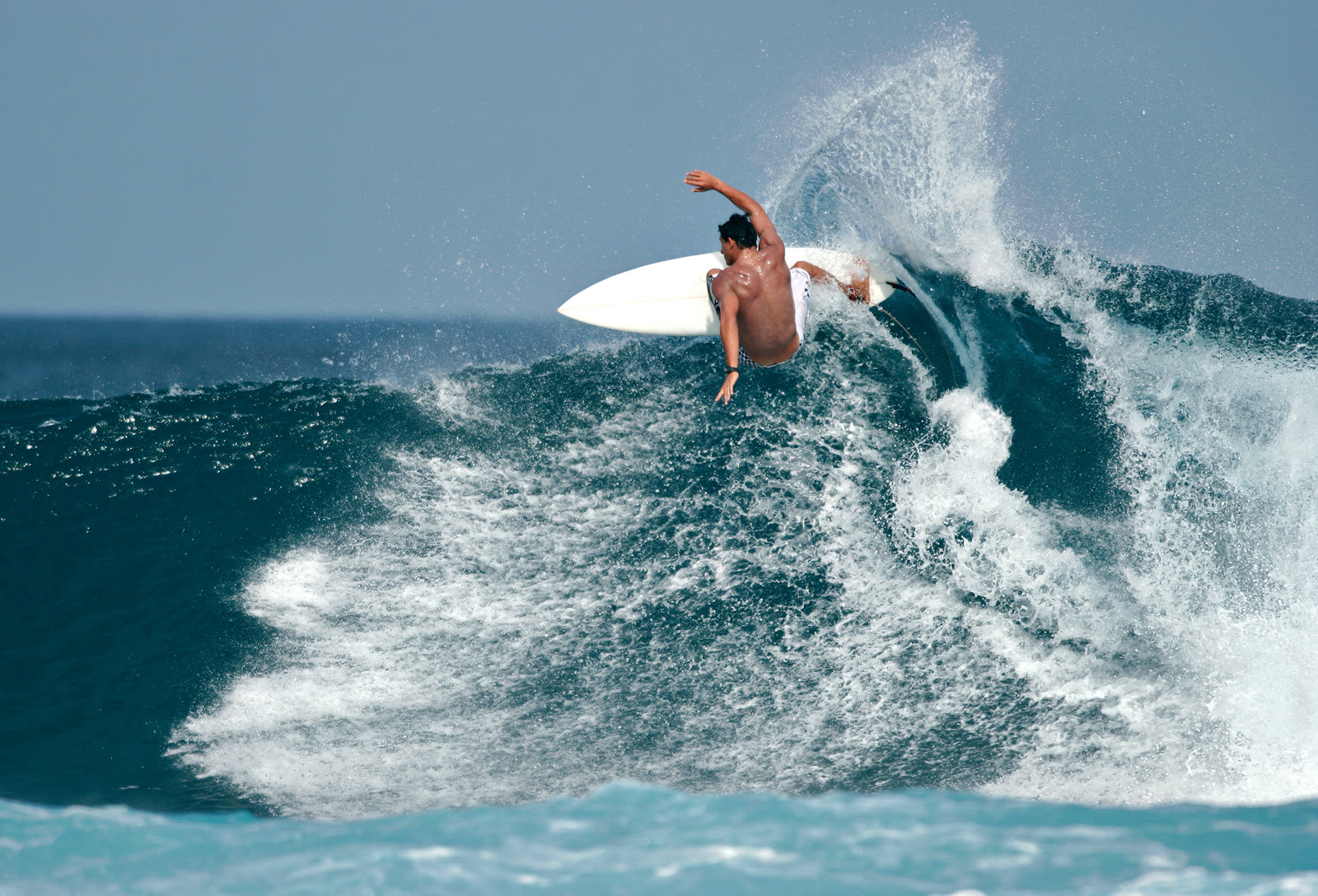 A surfer driving through a powerful turn